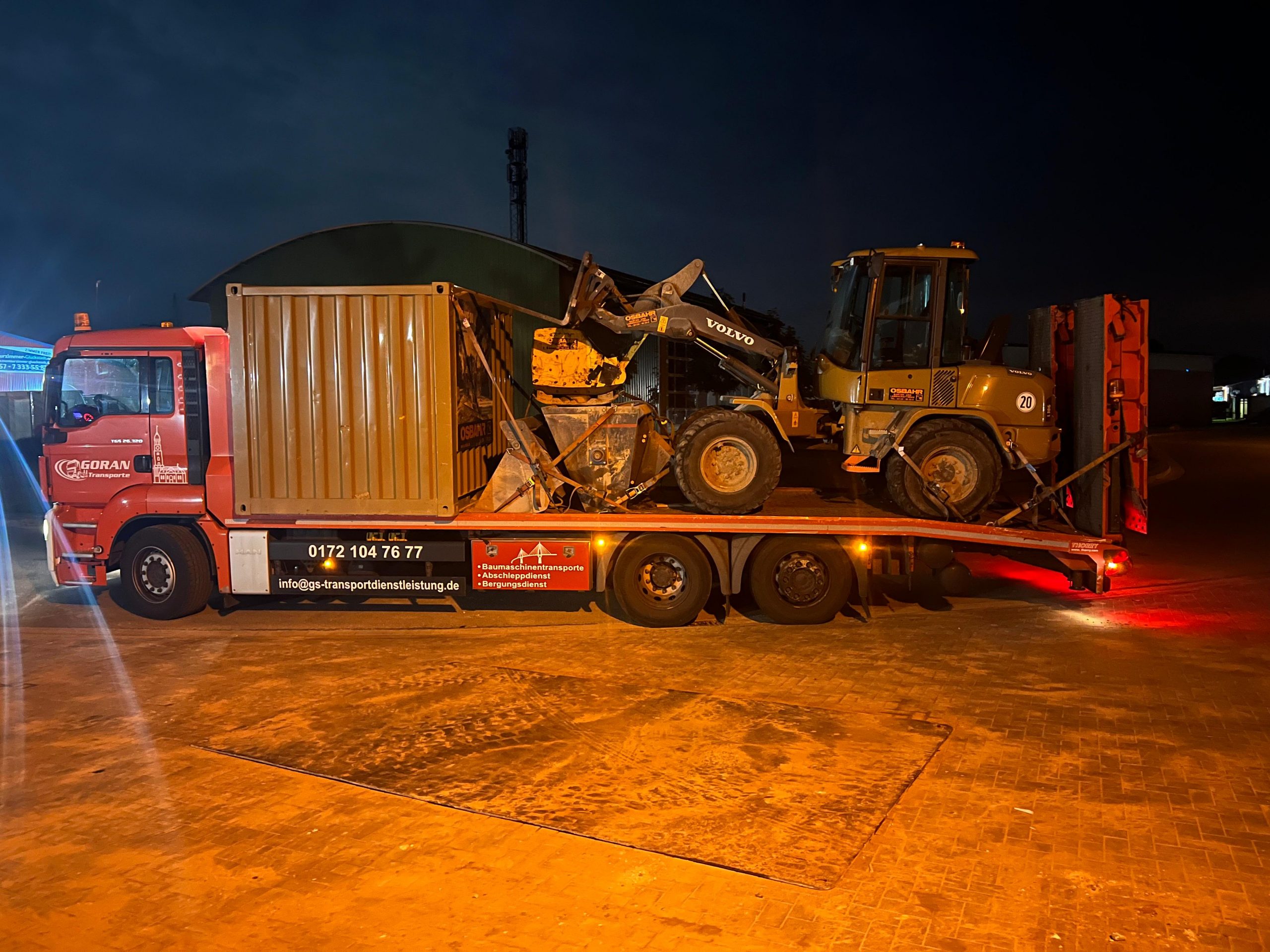 Transport vom Baustellencontainer und Bagger mit dem 3-Achser