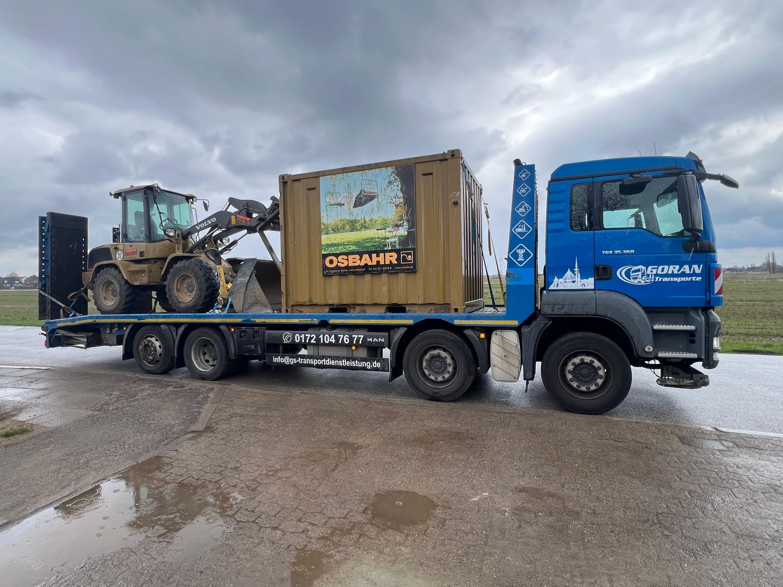 Transport vom Baustellencontainer und Bagger mit dem 4-Achser